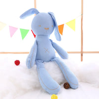 Blue kawaii bunny plush rabbit doll on a fluffy white surface with colorful flags in the background, perfect for toddlers and babies.