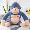 Blue plush orangutan toy with a cute facial expression, sitting on a bed, featuring soft fabric and a heart design on its chest.