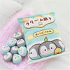 Snack Bag Plush Pillow with 8 Mini Penguin Toys on a Pink Blanket