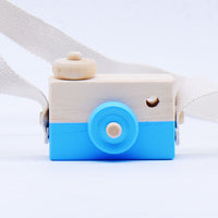 Wooden toy camera for kids with blue accents and a white strap, designed for pretend play and educational fun.