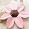 Pink sunflower-shaped baby bath mat with plush petals for infant bathing comfort.