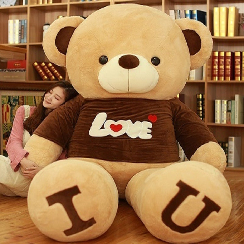 Giant plush teddy bear with "Love" shirt, featuring "I" and "U" on paws, next to a woman, ideal for cozy gifts and Valentine’s Day.