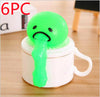 Green vomiting stress relief toy on a white cup for pranks and fun.