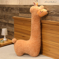 Large plush alpaca pillow in bedroom setting, soft stuffed toy for sleeping and gifting.