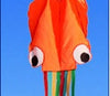 Colorful 3D octopus kite with vibrant stripes flying against a clear blue sky.