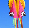 Colorful 3D octopus kite flying in a clear blue sky, showcasing its vibrant design and long, flowing tails.