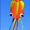 Colorful 3D octopus kite flying in a clear blue sky, featuring vibrant orange and green colors with long, trailing ribbons.