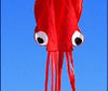 Large red 3D octopus kite with handle and line against a clear blue sky, ideal for beach and park outings.