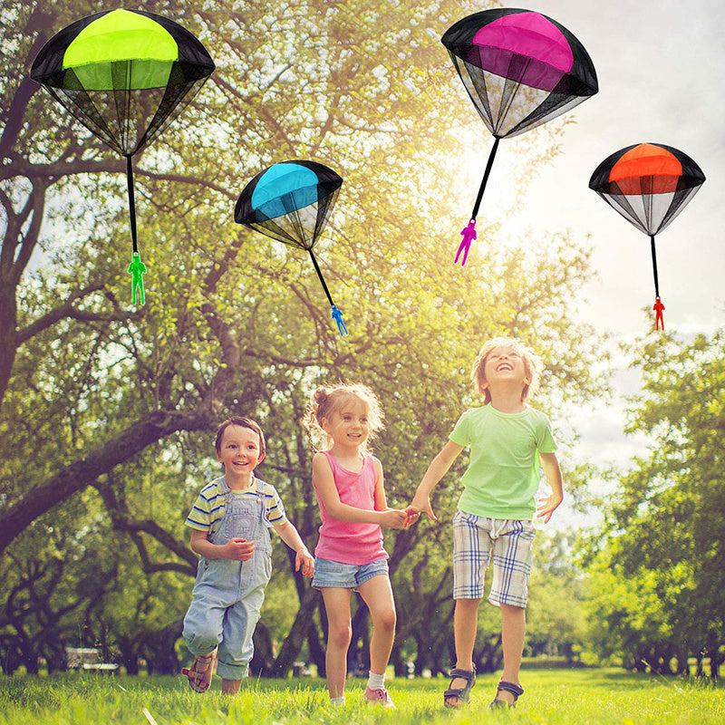 Children play with colorful mini soldier parachute toys outdoors, enjoying fun and developing motor skills in a park setting.