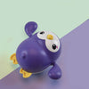 Cute purple penguin bath toy with wind-up feature for swimming and walking, perfect for baby bath fun and skill development.