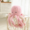 Pink octopus plush pendant with curly tentacles, perfect for gifts and home decor, on display in a cozy room setting.