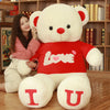 Woman hugging oversized heart bear plush pillow with "Love" message, perfect Valentine's Day gift.