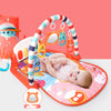 Baby enjoying tummy time on a colorful play gym with piano keys and hanging toys, enhancing sensory and motor skills.