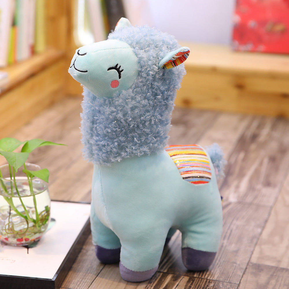 Soft alpaca llama plush toy with vibrant colors on a wooden floor, perfect for kids and gifts.