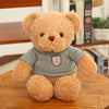 Teddy Bear Plush Toy in Gray Sweater on Wooden Table, Perfect for Gifts and Décor