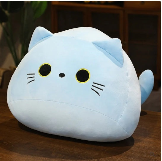 Cute blue cat-shaped plush pillow on a wooden table for home decor or cuddling.