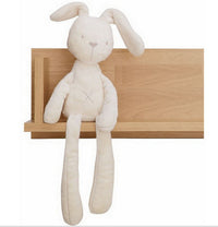 Soft plush bunny toy with long floppy ears sitting on a wooden shelf, perfect for kids and babies.