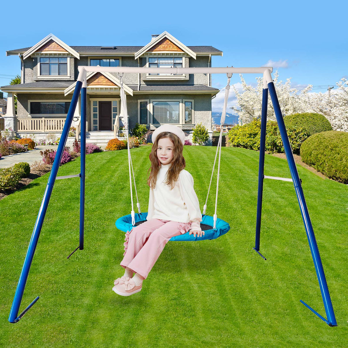 Child enjoying outdoor play on a metal swing set with disc swing in a backyard playground.