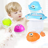 Child playing with colorful bath toys and suction cup marble run track in bathtub.