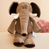 Jungle animal plush toy elephant with soft brown fabric, sitting on a beige surface, featuring realistic details and big floppy ears.