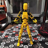 Movable 3D-printed shapeshift robot toy with flexible joints in yellow, set on a patterned surface, showcasing customizable poses.