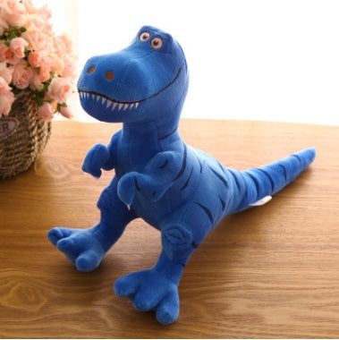 Blue dinosaur plush toy on wooden table, featuring an adorable cartoon Tyrannosaurus design with vibrant colors.