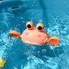 Cute crab-shaped floating bath toy in blue water, perfect for kids' bath time fun and motor skills development.