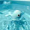 Cute blue whale clockwork bath toy floating in water, perfect for kids' water play and enhancing motor skills.