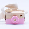 Wooden toy camera with pink accents for pretend play, featuring a pivotable lens and strap. Eco-friendly educational toy for kids.