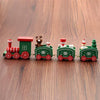 Mini wooden Christmas train set with festive designs on a wooden surface, featuring vibrant holiday characters and decorations.