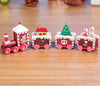 Mini wooden Christmas train set with festive red and green designs on a wooden surface. Perfect holiday décor ornament gift.