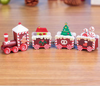 Mini wooden Christmas train set with festive red and green designs on a wooden surface. Perfect holiday décor ornament gift.