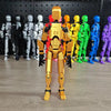 Movable shapeshift robot action figure in gold with colorful figures in background, showcasing customizable poses and 3D-printed design.