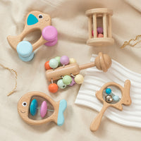 Wooden baby rattle drum set on cloth, featuring colorful beech wood toys for newborn sensory play and musical development.