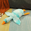 Big white goose plush doll pillow with orange beak and feet on a colorful rug, perfect for cuddling and home decoration.