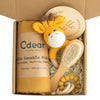 Baby teething toy gift set with muslin swaddle, giraffe plush, baby brush, and wooden milestone in a box.