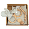 Baby teething toy gift set with wooden rings, gauze blanket, and beaded pacifier clip in a box for sensory and grip development.