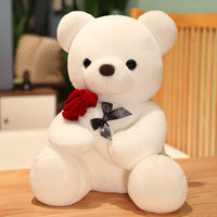 Plush white teddy bear holding a red rose, perfect for gifting and cuddling.