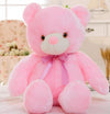 Pink plush teddy bear with a ribbon, perfect for gifts and décor.