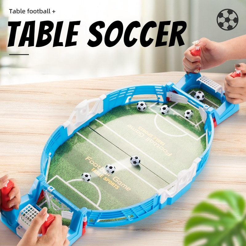 Mini tabletop soccer game with blue edges, being played by two hands, includes four soccer balls and green field design.