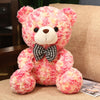 Pink and yellow Valentine’s Day teddy bear plush doll with bow tie on a couch, perfect romantic gift.