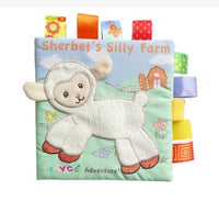 Soft baby cloth book with embroidered lamb on cover, vibrant ribbons, and farm theme for sensory play and learning.