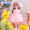 Articulated 1/6 BJD doll in pink dress with bunny ears, sitting on a pink bench surrounded by flowers. Perfect for girls' play.