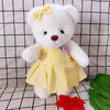 Little Bear Plush Doll in yellow dress with a bow, kawaii design, on a checkered background. Perfect for cuddling and dress-up fun.