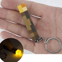 Person holding Minecraft glow keychain torch pendant with LED light, ideal for fans and as a convenient, stylish accessory.