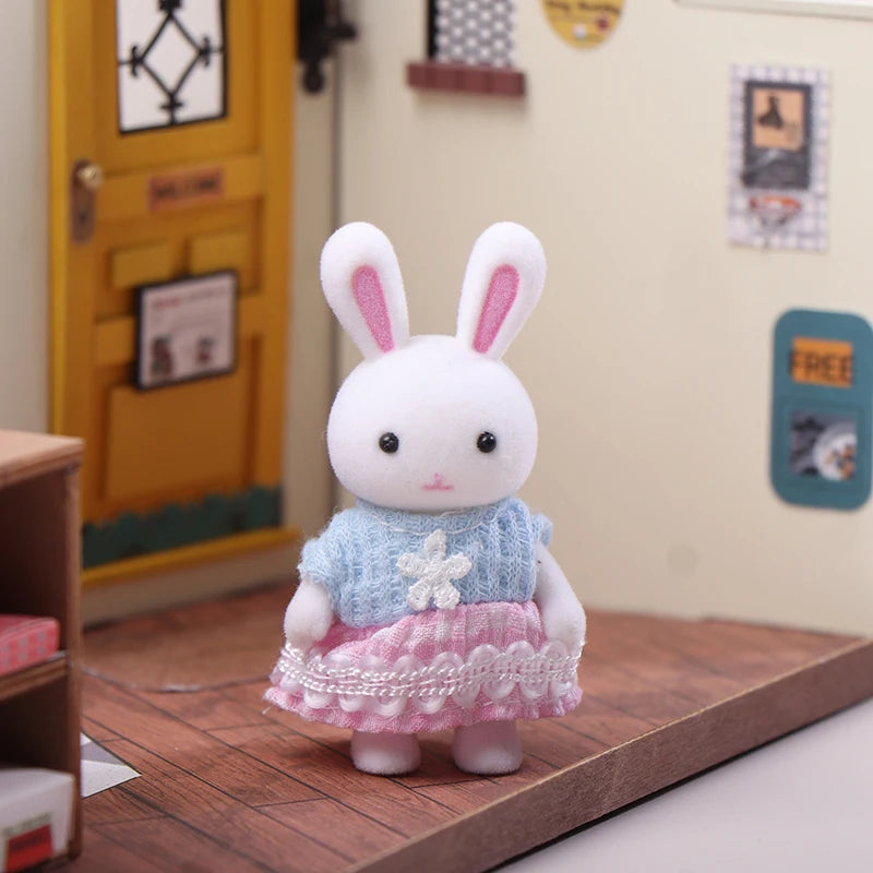 Miniature dollhouse rabbit critter with blue sweater and pink skirt in a pretend playroom setting.