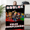 Woman holding a Roblox-themed blanket with characters and "Feliz Cumpleaños" text, perfect for cozy gaming and celebrations.