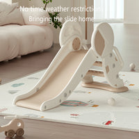 Indoor kids slide set on play mat in living room, promoting safe fun and physical activity for toddlers and young children.