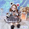 Fashion doll with heart ear headband and checkered dress, surrounded by a decorative lamp and flowers.