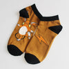 Brown Raichu-themed cotton socks with black trims, featuring soft plush material for comfort. Perfect for Pokemon fans.